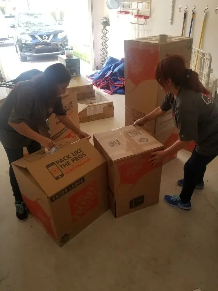 Two ETG team members packing boxes in a client home