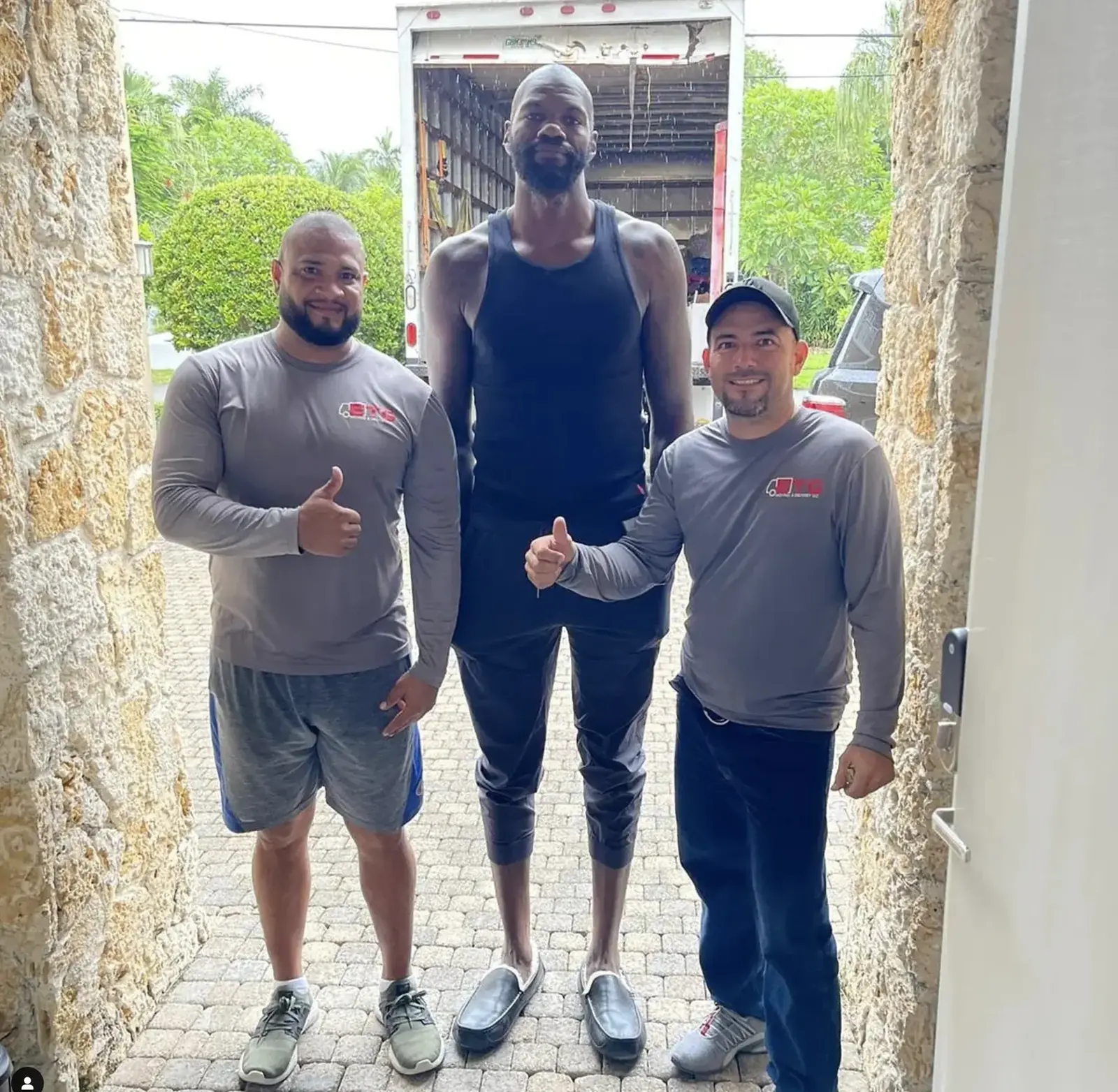 Three ETG movers in company shirts at a client home with the truck